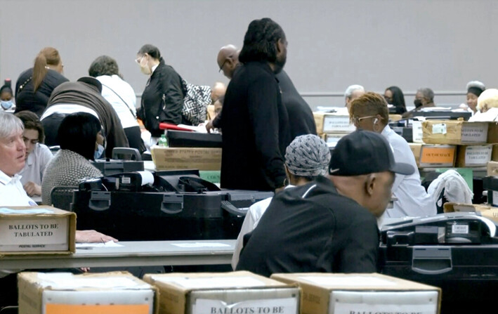 Las autoridades electorales comienzan a clasificar y contar las papeletas en el centro de convenciones Huntington Place de Detroit, Michigan, el 27 de febrero de 2024. (Reuters/Captura de pantalla vía NTD)