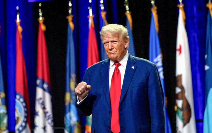 El expresidente Donald Trump levanta el puño mientras saluda a la multitud antes de hablar durante la 146° Conferencia y Exhibición General de la Asociación de la Guardia Nacional de Estados Unidos, en el Centro de Convenciones Huntington Place, en Detroit, Michigan, el 26 de agosto de 2024. (Emily Elconin/Getty Images)