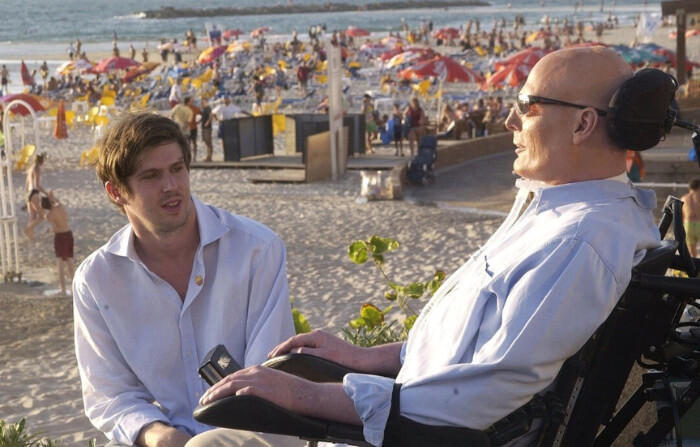 El exactor Christopher Reeve (dcha.) y su hijo Matthew (izq.) conversan en el paseo marítimo con vistas al mar Mediterráneo en Tel Aviv, Israel, el 1 de agosto de 2003. (Israel Hadari-Pool/Getty Images). 
