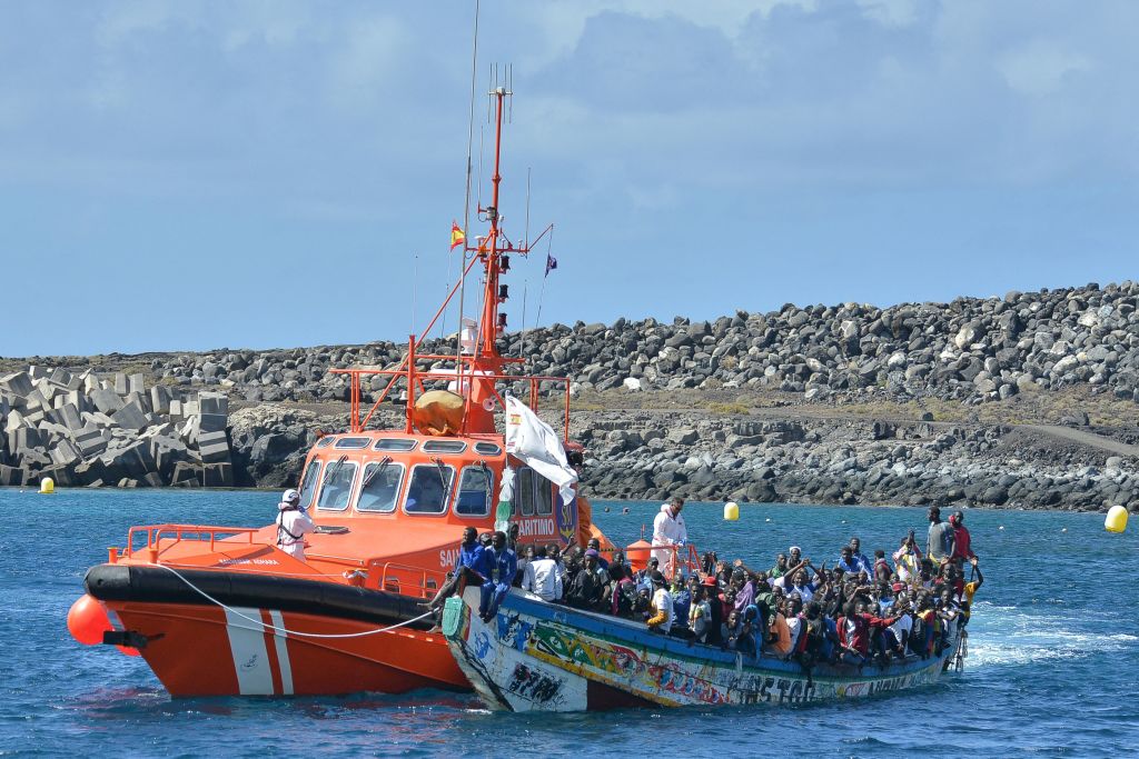 La embarcación española de Salvamento Marítimo "Salvamar Adhara" aborda una patera con inmigrantes en el muelle de La Restinga, en el municipio de El Pinar, en la isla canaria de El Hierro, el 21 de octubre de 2023. (STRINGER/AFP vía Getty Images)