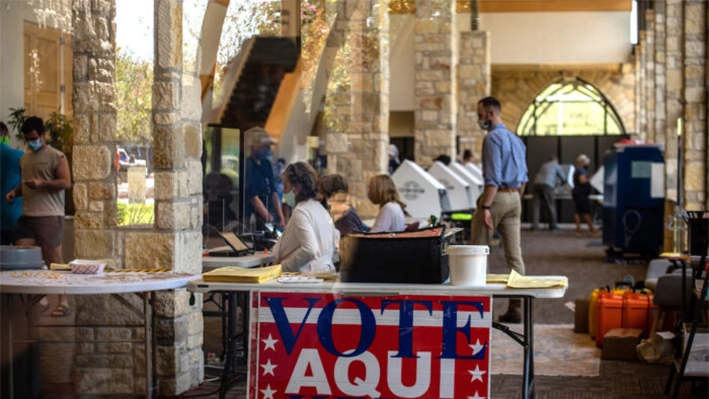 Trabajadores electorales ayudan a los votantes dentro de un centro de votación en Austin, Texas, el 13 de octubre de 2020. (Sergio Flores/Getty Images)
