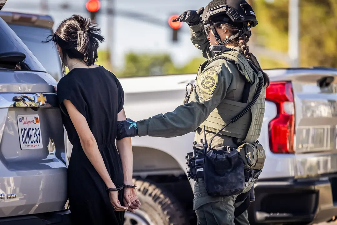 La policía detiene a varias personas durante una redada en un emplazamiento ilegal de cannabis en Lancaster, California, el 14 de agosto de 2024. (John Fredricks/The Epoch Times)