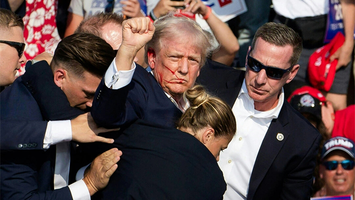 El expresidente Donald Trump con sangre en la cara rodeado de agentes del servicio secreto en Butler Farm Show Inc. en Butler, Pensilvania, el 13 de julio de 2024. (Rebecca Droke/AFP vía Getty Images)