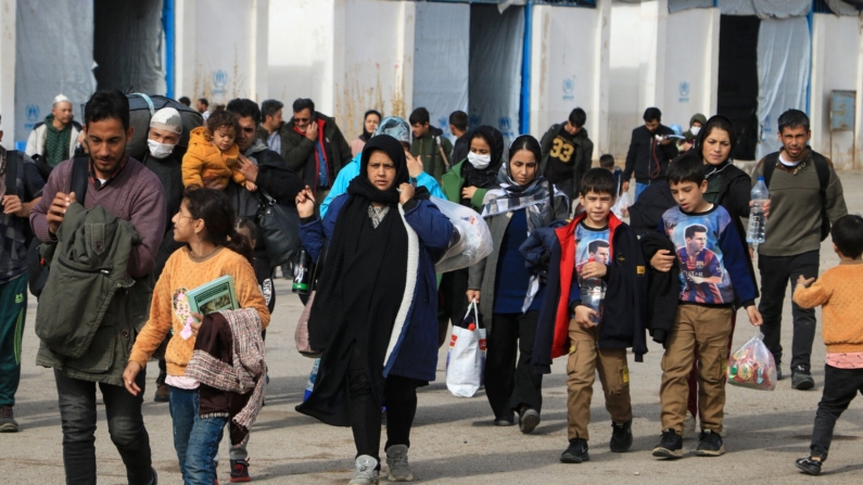 Inmigrantes afganos deportados desde Irán cargan sus pertenencias en un centro de registro en la ciudad fronteriza de Islam Qala, en la provincia de Herat, el 6 de noviembre de 2023. (MOHSEN KARIMI/AFP via Getty Images)