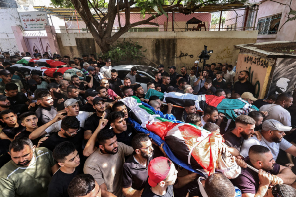 Los dolientes marchan con los cuerpos de cuatro palestinos que murieron en una operación militar israelí durante su funeral en el campo de refugiados palestinos de Fara, cerca de Tubas, en el norte de la Cisjordania ocupada, el 29 de agosto de 2024. (Zain Jaafar/AFP vía Getty Images )