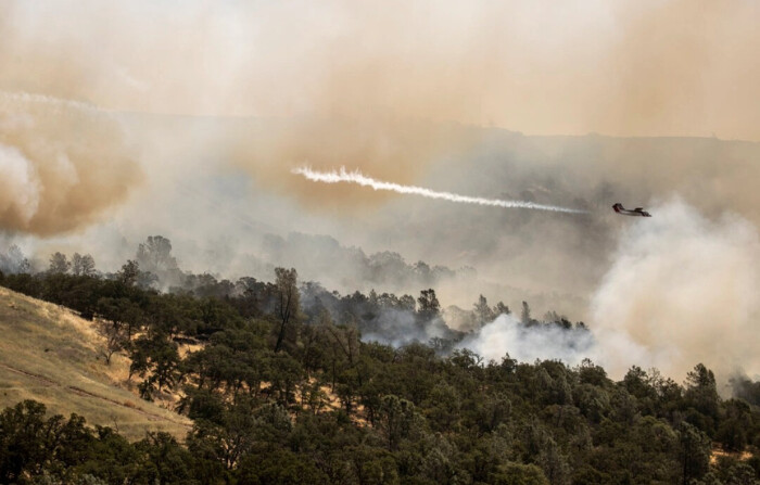 Un avión táctico aéreo OV-10 de Cal Fire suelta una bocanada de humo mientras guía un lanzamiento de retardante de incendios durante el incendio Thompson, en Oroville, California, el miércoles 3 de julio de 2024. (Stephen Lam/San Francisco Chronicle vía AP). 
