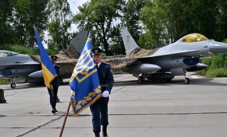 Militares ucranianos portan banderas tras una ceremonia celebrada con motivo del Día de las Fuerzas Aéreas Ucranianas en una zona no revelada el 4 de agosto de 2024. (Sergei Supinsky/AFP)