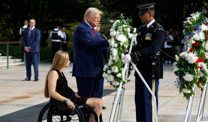 El candidato presidencial republicano, el expresidente Donald Trump, deposita una corona de flores junto al cabo de la Marina Kelsee Lainhart (retirado), que resultó herido en el atentado de Abbey Gate, durante una ceremonia de colocación de coronas en la Tumba del Soldado Desconocido en el Cementerio Nacional de Arlington en Arlington, Virginia, el 26 de agosto de 2024. (Anna Moneymaker/Getty Images). 
