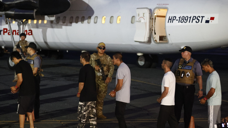 Migrantes esposados antes de ser deportados en el aeropuerto Marcos A. Gelabert en Ciudad de Panamá. (EFE/ Bienvenido Velasco)