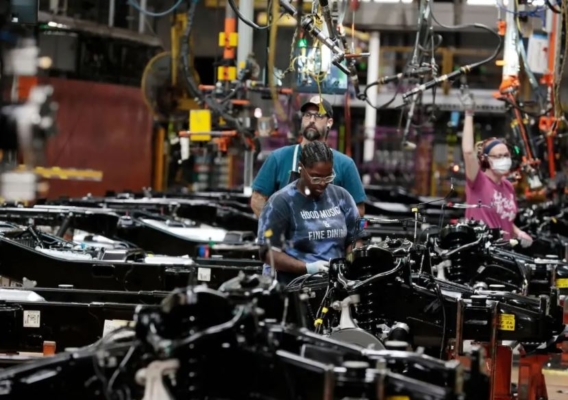 Trabajadores colocan motores en el bastidor de camiones F-150 de combustible de Ford Motor Co. en producción en su planta de camiones en Dearborn, Michigan, el 20 de septiembre de 2022. (Jeff Kowalsky/AFP vía Getty Images)