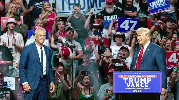 El ex presidente y candidato presidencial republicano Donald Trump (d) recibe en el escenario al candidato presidencial independiente Robert F. Kennedy Jr (i) durante un mitin de campaña en el Desert Diamond Arena de Glendale, Arizona, el 23 de agosto de 2024. (Olivier Touron/AFP vía Getty Images)
