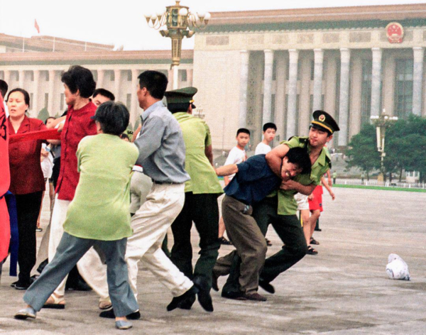 Practicantes de Falun Gong son detenidos por policías chinos mientras expresan sus creencias, en la plaza de Tiananmen de Beijing el 19 de julio de 2000. (Chien-min Chung/Foto AP)