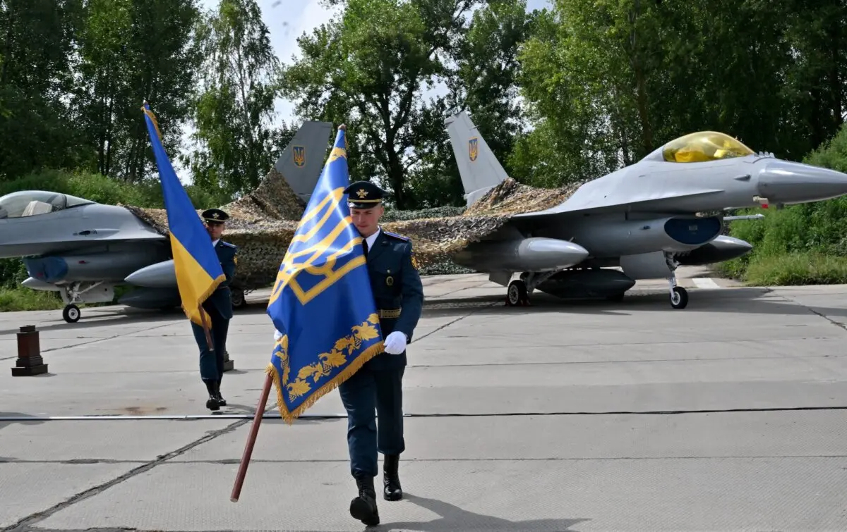 Militares ucranianos portan banderas tras una ceremonia celebrada con motivo del Día de las Fuerzas Aéreas Ucranianas en una zona no revelada el 4 de agosto de 2024. (Sergei Supinsky/AFP)