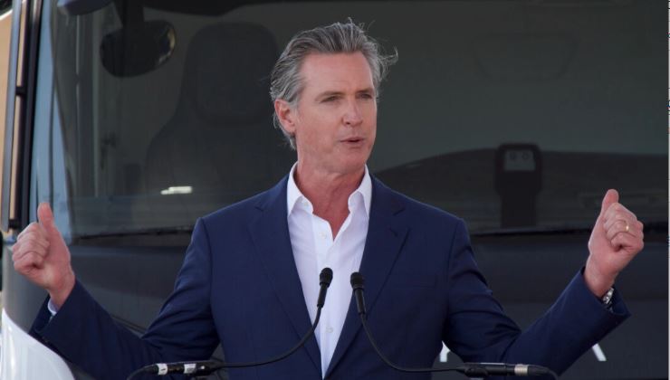 El gobernador Gavin Newsom señala camiones propulsados por hidrógeno durante una rueda de prensa para celebrar la inauguración de la primera estación comercial de hidrógeno del mundo en Oakland, California, el 30 de agosto de 2024. (Travis Gillmore/The Epoch Times)