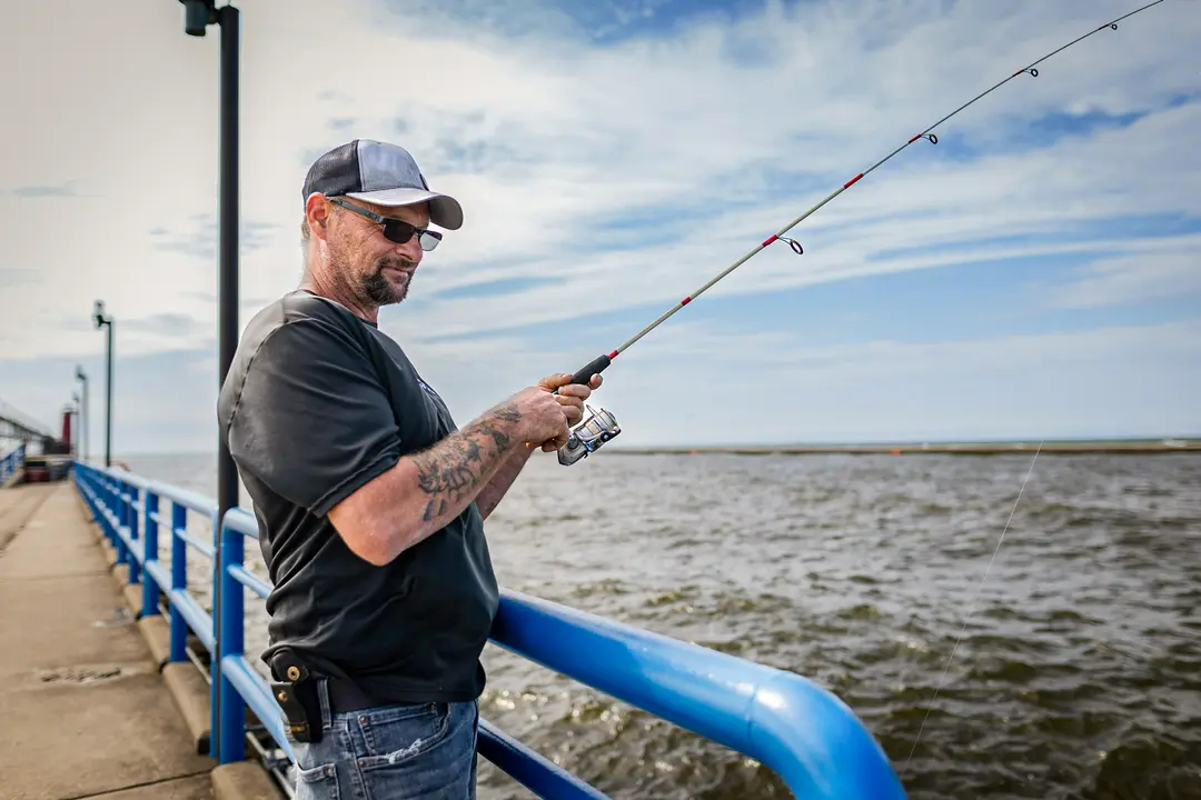 Dirk O'Brien pesca en un muelle de Grand Haven, Michigan, el 28 de agosto de 2024. (John Fredricks/the Epoch Times)