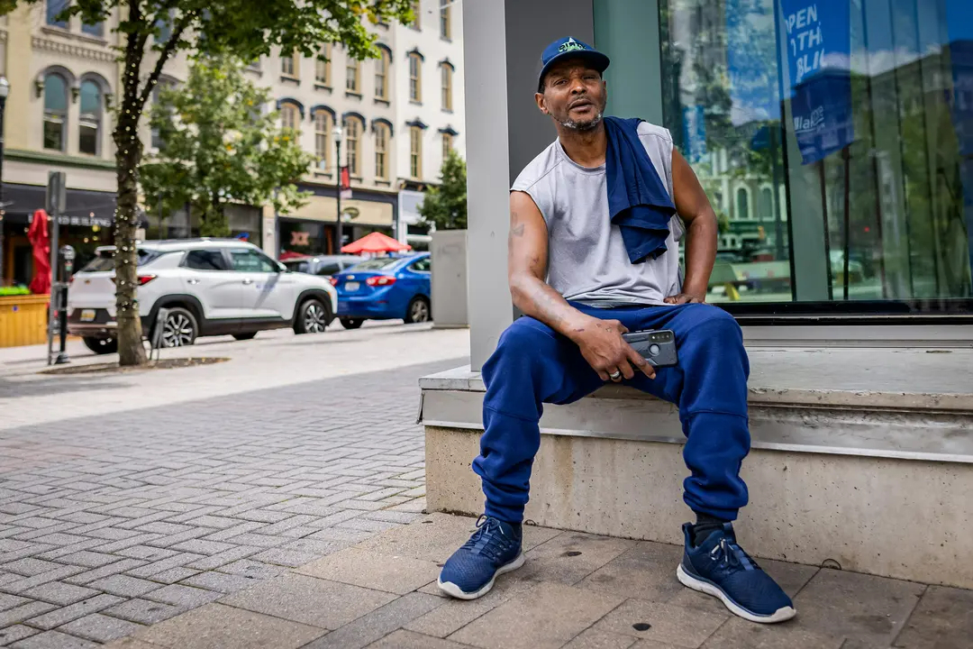 Germaine Green sentada cerca de una concurrida calle de Grand Rapids, Michigan, el 28 de agosto de 2024. (John Fredricks/The Epoch Times)