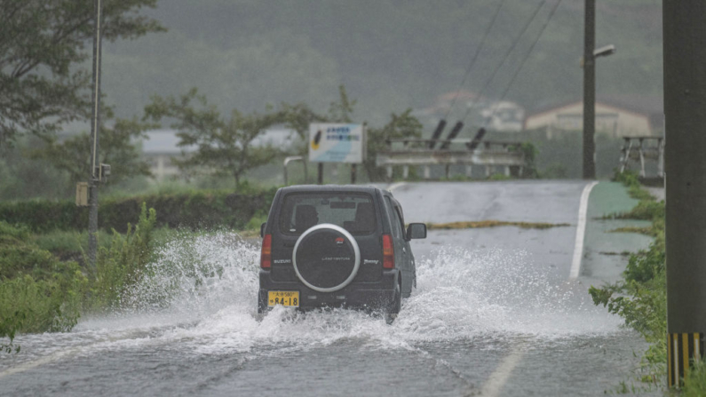 Un coche atraviesa una calle inundada en la ciudad de Yufu, en la prefectura de Oita (Japón), el 29 de agosto de 2024. (Yuichi Yamazaki/AFP vía Getty Images)