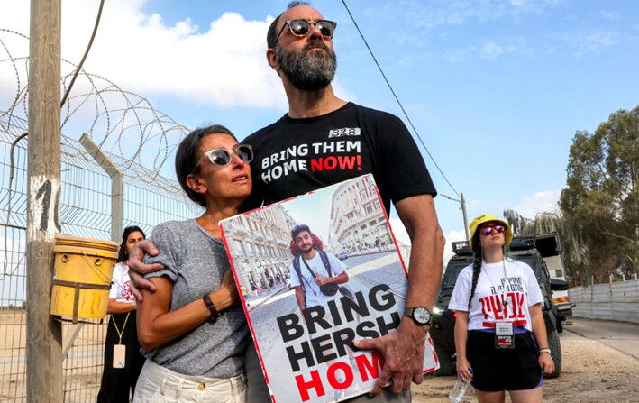 Rachel y Jon, los padres del rehén Hersh Goldberg-Polin, quien fue secuestrado en el ataque de Hamás contra Israel el 7 de octubre, sostienen su foto mientras llaman a sus seres queridos cautivos cerca de la frontera con la Franja de Gaza en Nirim, Israel, el 29 de agosto de 2024. (Jack Guez/AFP vía Getty Images)