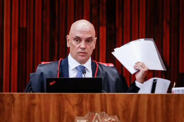 El presidente del Tribunal Superior Electoral de Brasil, Alexandre de Moraes, sostiene documentos durante el cuarto día del juicio al expresidente brasileño Jair Bolsonaro, acusado de abuso de poder y desinformación, en Brasilia el 30 de junio de 2023. (Sergio Lima/AFP vía Getty Images)