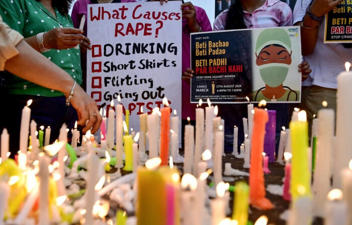 Profesionales médicos encienden velas y sostienen carteles durante una manifestación en medio de la huelga nacional de médicos para condenar la violación y asesinato de un joven médico de Calcuta, a lo largo de una calle en Jalandhar el 17 de agosto de 2024. (Shammi Mahra / AFP vía Getty Images). 