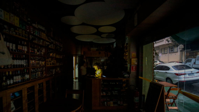 Un empleado de una bodega trabaja a oscuras debido al apagón que afecta a varios barrios de la región central de Sao Paulo, Brasil, el 20 de marzo de 2024. (Miguel Schincariol/AFP vía Getty Images)