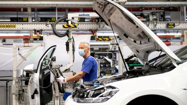 Un trabajador lleva una máscara protectora en la línea de montaje de Volkswagen después de que el fabricante de automóviles reinicie la fábrica de automóviles más grande de Europa después de un cierre tras la pandemia de coronavirus, en Wolfsburg, Alemania, el 27 de abril de 2020. (Swen Pfoertner/Pool vía Reuters)
