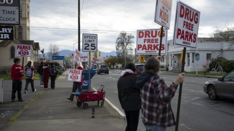 Personas protestan contra el consumo abierto de drogas en parques frente al Ayuntamiento de Grants Pass, Oregón, el 20 de marzo de 2024. (AP Photo/Jenny Kane)