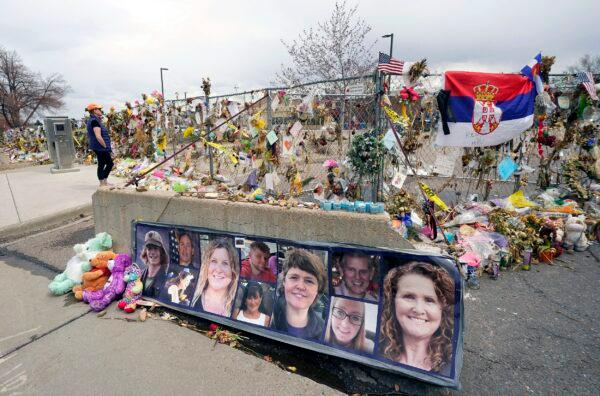 Fotos de las 10 víctimas de un tiroteo en una tienda de comestibles King Soopers se colocan en una barrera de cemento fuera del supermercado en Boulder, Colorado, el 23 de abril de 2021. (David Zalubowski/Foto AP)