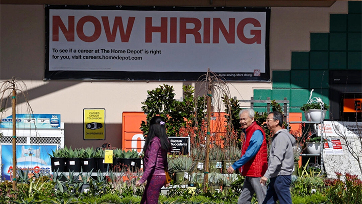 Clientes de Home Depot caminan junto a un cartel de "Ahora contratando" en San Rafael, California, el 8 de marzo de 2024. (Justin Sullivan/Getty Images)
