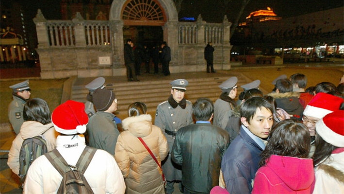 Guardias de seguridad chinos junto con policías mantienen alejados a cientos de fieles cristianos chinos de la iglesia católica de Wangfujing durante la misa de Navidad en Beijing el 25 de diciembre de 2003, en esta foto de archivo. (Goh Chai Hin/AFP vía Getty Images)
