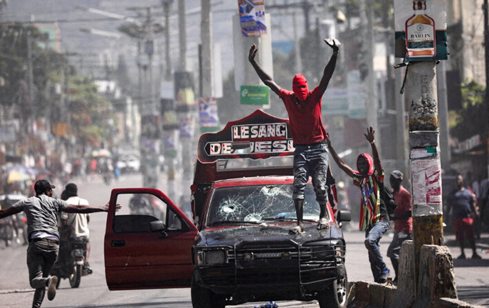 Un hombre con el rostro cubierto llama a los manifestantes a detenerse durante una protesta contra el gobierno del primer ministro Ariel Henry, en Puerto Príncipe, Haití, el 1 de marzo de 2024. (Ralph Tedy Erol/Reuters)