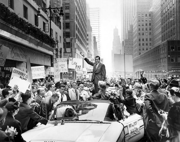 El vicepresidente y candidato presidencial Richard Nixon (centro) y su esposa Pat (centro abajo) saludan a la multitud que se reunió para verlos salir del Hotel Commodore en Nueva York, el 28 de septiembre de 1960. (AFP vía Getty Images)