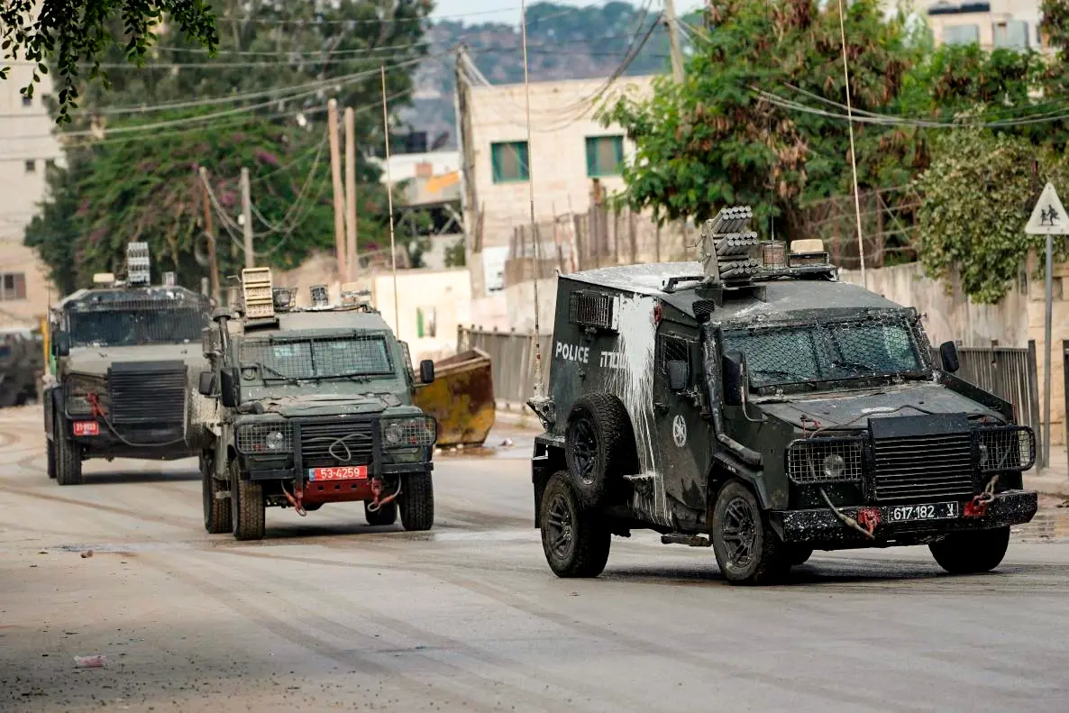 Una fila de vehículos blindados israelíes sale tras una operación antiterrorista en Tubas, Cisjordania, el 14 de agosto de 2024. (Majdi Mohammed/AP)