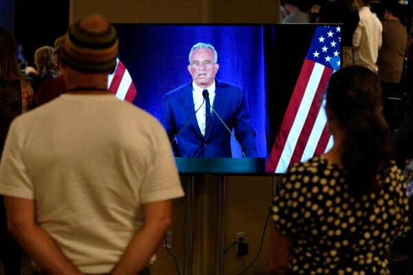 Varias personas observan en un monitor cómo el candidato presidencial independiente Robert F. Kennedy Jr. anuncia que suspende su campaña presidencial en una rueda de prensa el 23 de agosto de 2024, en Phoenix. (AP Photo/Darryl Webb)