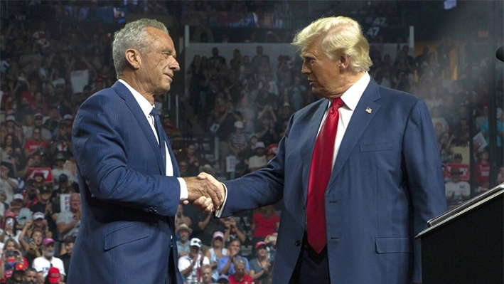 El candidato presidencial independiente Robert F. Kennedy Jr. y el candidato presidencial republicano, el expresidente estadounidense Donald Trump, se dan la mano durante un mitin de campaña en el Desert Diamond Arena de Glendale, Arizona, el 23 de agosto de 2024. (Rebecca Noble/Getty Images)
