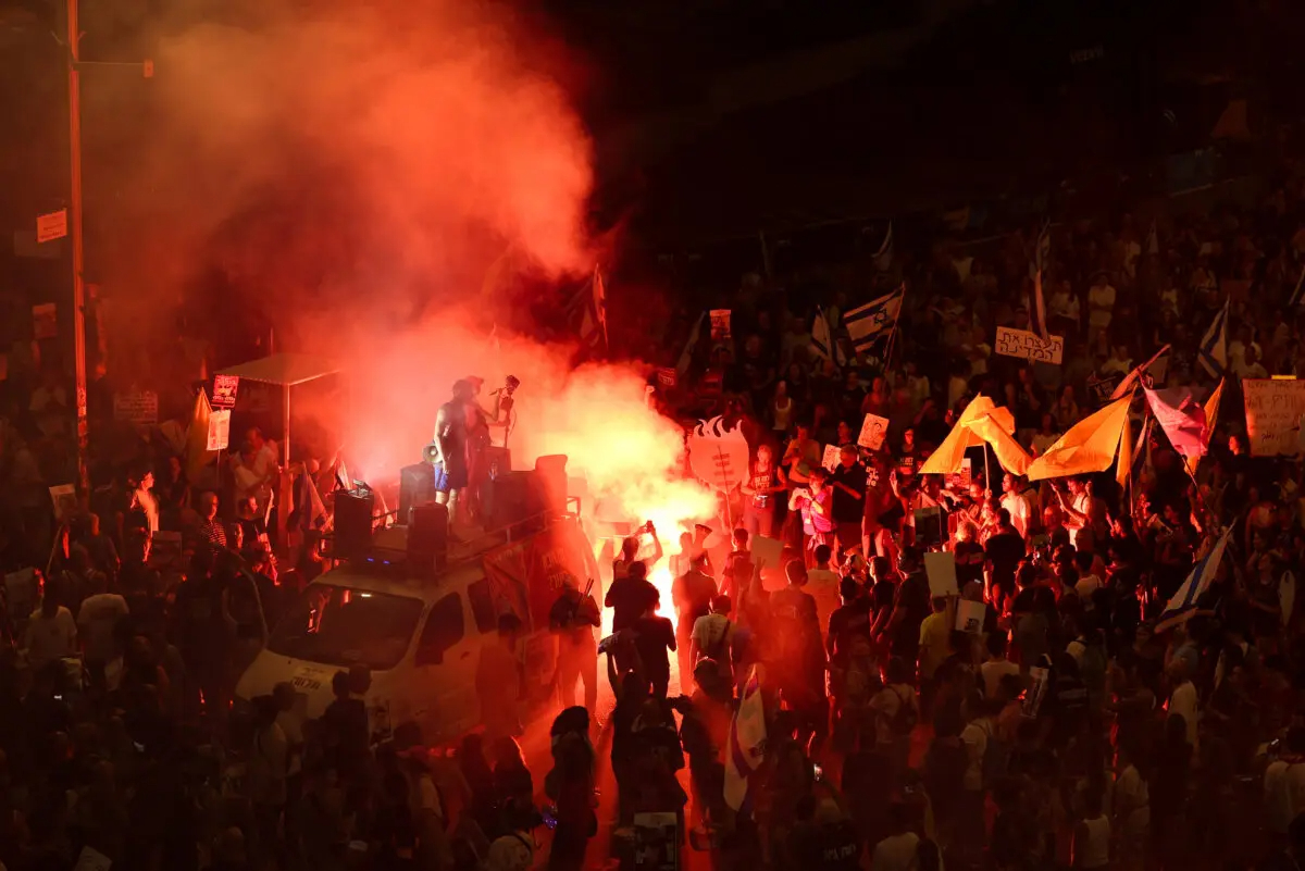 Manifestantes encienden bengalas y ondean banderas israelíes durante una protesta en la que se pide la liberación de los rehenes israelíes cautivos desde el atentado perpetrado por la organización terrorista Hamás el 7 de octubre de 2023, en Tel Aviv, Israel, el 3 de septiembre de 2024. (Jack Guez/AFP vía Getty Images)