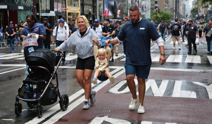 Un desfile es aún más divertido cuando tus padres te permiten columpiarte en la Quinta Avenida durante el desfile anual del Día del Trabajo en la ciudad de Nueva York el 7 de septiembre de 2024. (Richard Moore/ The Epoch Times)