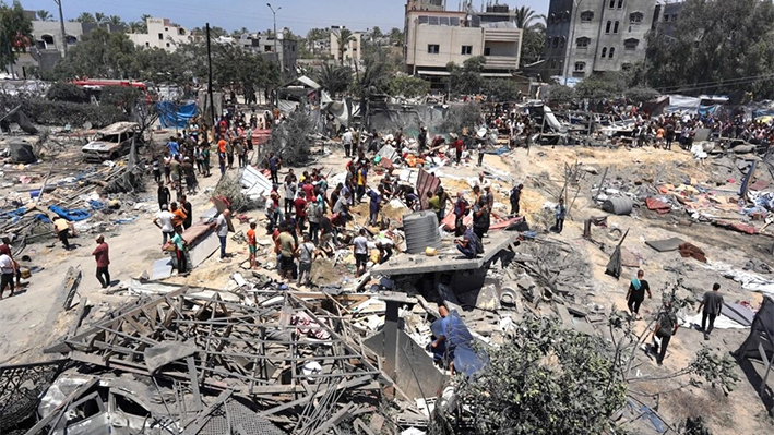 Varios gazatíes observan los escombros tras un ataque militar israelí cerca de la ciudad de Jan Yunis, en el sur de la Franja de Gaza, el 13 de julio de 2024. (Bashar Taleb/AFP vía Getty Images)
