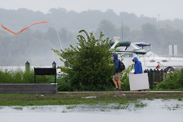 La gente camina por una acera junto al río Potomac cerca de Old Town Alexandria el 9 de agosto de 2024 en Alexandria, Virginia. El área de Washington DC experimentó una advertencia de tornado e inundaciones como resultado de los restos del huracán Debby que se ha desplazado hacia la costa este. (Anna Moneymaker/Getty Images)