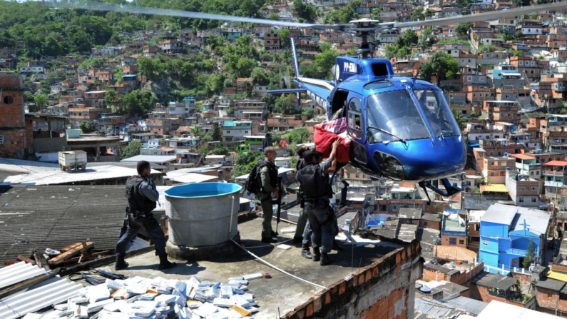 Policías de las Fuerzas Especiales Antidisturbios cargan un helicóptero con seis toneladas de marihuana encontradas en un búnker durante una redada en la favela Morro do Alemao el 28 de noviembre de 2010 en Río de Janeiro, Brasil. (Evaristo Sa/AFP vía Getty Images)