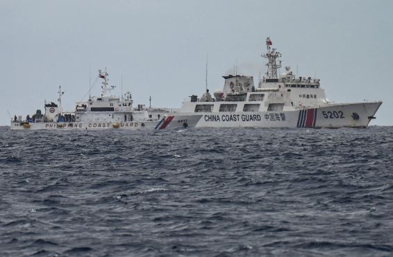 Un buque guardacostas chino (dcha.) pasa junto al buque guardacostas filipino BRP Cape Engaño (izda.), fotografiado desde el BRP Cabra durante una misión de suministro en aguas en disputa del Mar de China Meridional, el 26 de agosto de 2024. (Jam Sta Rosa/AFP vía Getty Images)