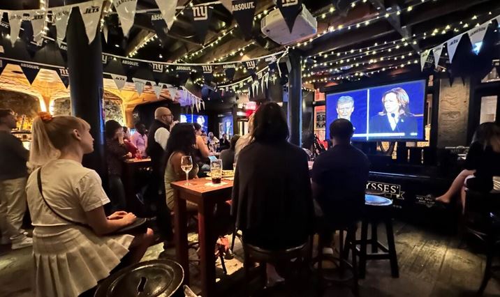 Asistentes a una fiesta de observación del debate presidencial en el bar y restaurante Ulysses de Nueva York el 10 de septiembre de 2024. (Juliette Fairley/The Epoch Times)