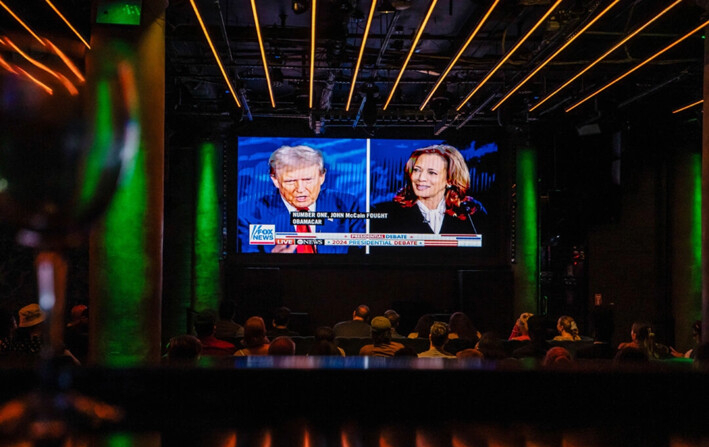 La gente observa el debate presidencial entre la candidata presidencial demócrata, la vicepresidenta Kamala Harris, y el candidato presidencial republicano, el expresidente Donald Trump, en el bar y salón Slate de la ciudad de Nueva York, el 10 de septiembre de 2024. (Samira Bouaou/The Epoch Times)