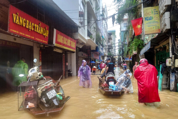 La gente camina por una calle inundada tras el impacto del tifón Yagi, en Hanoi, Vietnam, el 11 de septiembre de 2024. (Khanh Vu/Reuters)