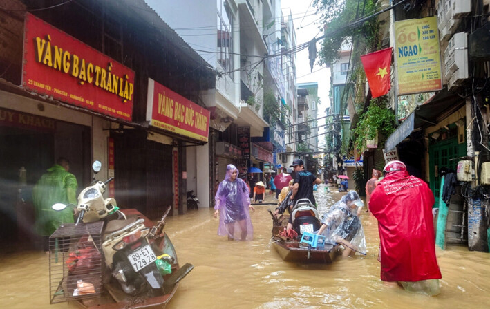 La gente camina por una calle inundada tras el impacto del tifón Yagi, en Hanoi, Vietnam, el 11 de septiembre de 2024. (Khanh Vu/Reuters)