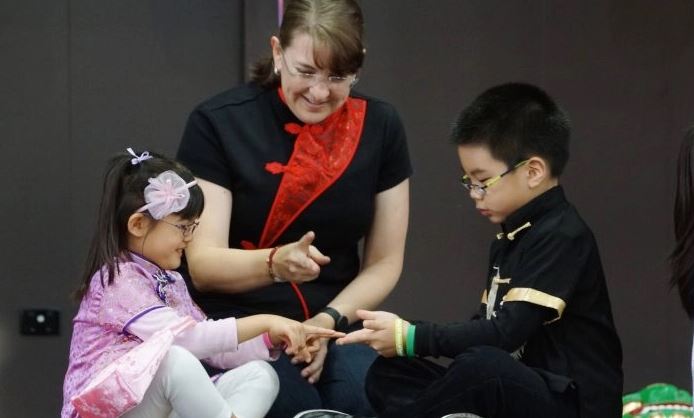 Niños adoptados aprendiendo sobre sus propias costumbres a través del juego en las celebraciones del 30º Día Internacional de la Adopción, el 5 de julio de 2015. (Linda Huang/Epoch Times)