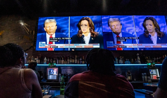 La gente ve el debate presidencial entre la vicepresidenta Kamala Harris y el expresidente Donald Trump, en una fiesta de observación en el bar y salón Slate en la ciudad de Nueva York el 10 de septiembre de 2024. (Samira Bouaou/The Epoch Times)