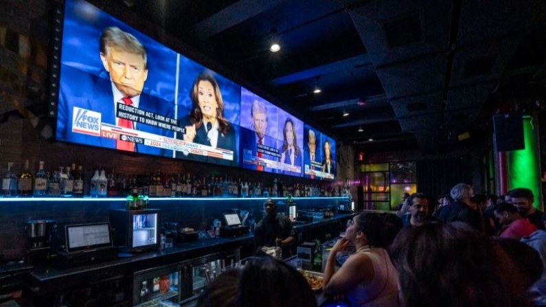 La gente ve el debate entre la candidata presidencial demócrata, la vicepresidenta Kamala Harris, y el candidato presidencial republicano, el expresidente Donald Trump,en un encuentro en el bar y salón Slate en Nueva York el 10 de septiembre de 2024. (Samira Bouaou/The Epoch Times)