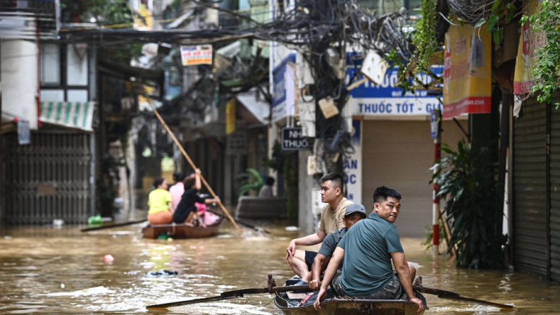 Personas se desplazan a través de las aguas inundadas en Hanoi el 12 de septiembre de 2024, mientras las fuertes lluvias posteriores al tifón Yagi provocaban inundaciones en el norte de Vietnam. (Nhac Nguyen/AFP vía Getty Images)