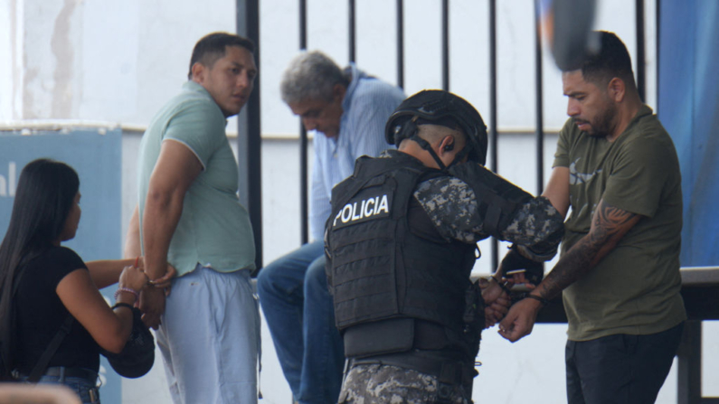 Presuntos miembros de la pandilla 'Chone Killer' son esposados ​​por agentes de policía después de ser arrestados en Durán, Ecuador, el 14 de agosto de 2024. (Gerardo Menoscal/AFP vía Getty Images)